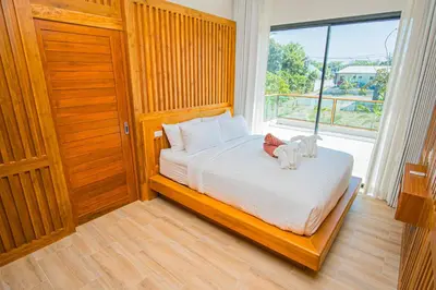 a bedroom with a bed with two stuffed animals on it at White Villa Phuket in Ban Saiyuan (1)