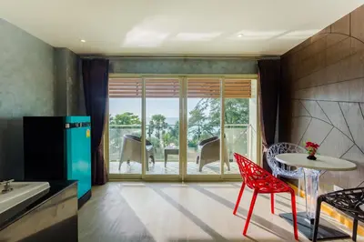 a kitchen with red chairs and a table and a patio at Anda Beachside Hotel in Karon Beach