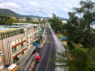 a city street with buildings and a road with a red truck at Anda Beachside Hotel in Karon Beach