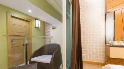 a bathroom with a chair and a shower at Anda Beachside Hotel in Karon Beach
