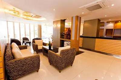 a living room with couches and a table and chairs at Anda Beachside Hotel in Karon Beach