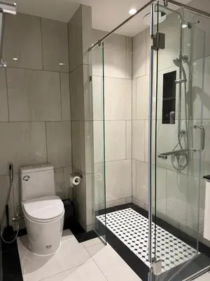 a bathroom with a toilet and a glass shower at The Title Legendary swimming pool in Phuket
