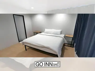 a bedroom with a white bed and a blue curtain at GO INN Phuket old Town in Ban Lo Long