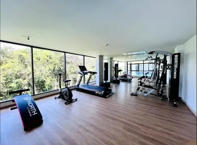 a gym with several treadmills and ellipticals in a building at VIP Great Hill Airport in Phuket
