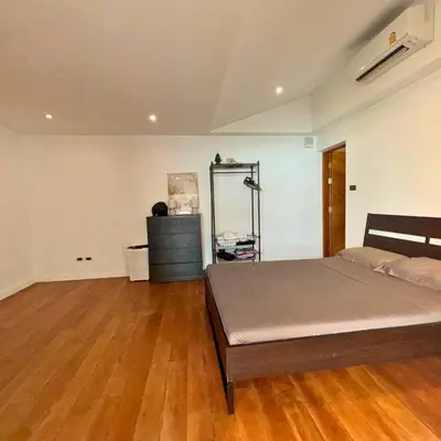 a bedroom with a bed and a wooden floor at Golf Paradise 4 BR Smart Home Pool Villa at Loch Palm Golf Course Kathu in Ban Kathu