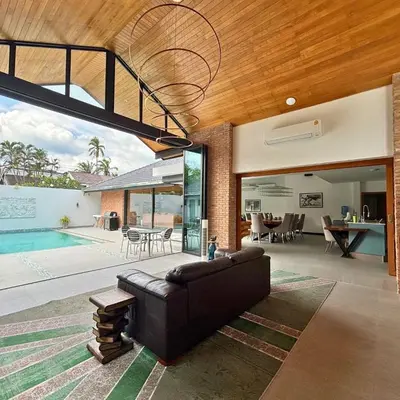 a living room with a couch and a pool at Golf Paradise 4 BR Smart Home Pool Villa at Loch Palm Golf Course Kathu in Ban Kathu