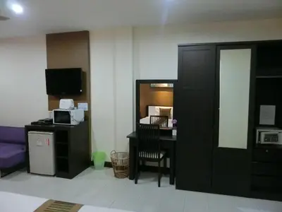 a hotel room with a desk and a room at Bed & Bath in Kata Beach