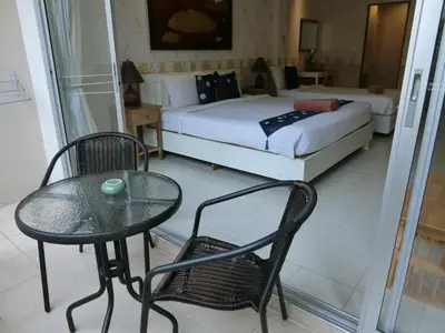 a bedroom with a bed and a table and chair at Bed & Bath in Kata Beach