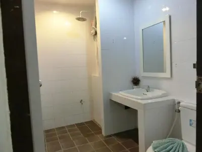 a white bathroom with a sink and a mirror at Bed & Bath in Kata Beach