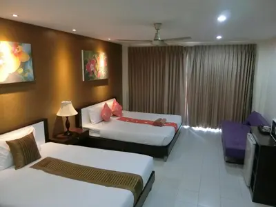 a hotel room with two beds and a television at Bed & Bath in Kata Beach