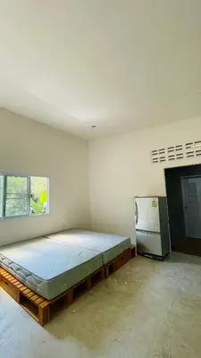 a bedroom with a bed and a refrigerator in it at House of Lee-Party room in Ban Huai Sai