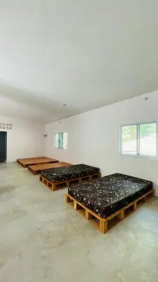 a row of mattresses in a large room at House of Lee-Party room in Ban Huai Sai
