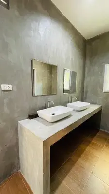 a bathroom with two sinks on a concrete wall at House of Lee-Party room in Ban Huai Sai