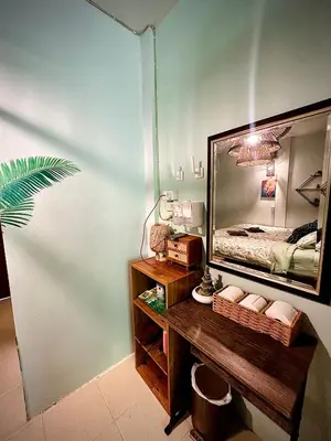 a bedroom with a large mirror and a wooden table at MILD ISLAND STAY ROOm in Phi Phi Don