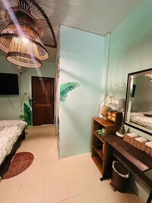 a bedroom with a mirror and a bed and a table at MILD ISLAND STAY ROOm in Phi Phi Don