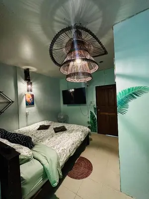 a bedroom with a bed and a large chandelier at MILD ISLAND STAY ROOm in Phi Phi Don
