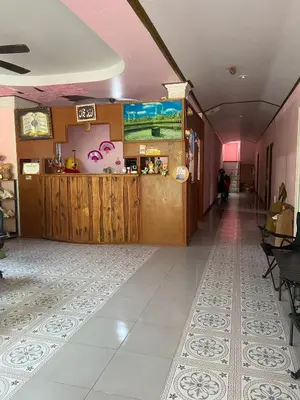 a corridor of a restaurant with a counter and a room at Kittiya Mansion in Ban Phlu Nai