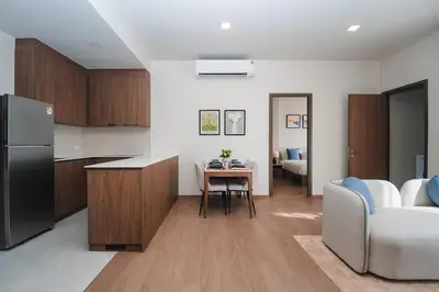 a kitchen and living room with a couch and a table at Casa tua, luxury 2bed - Canvas by Sansiri in Laguna Phuket