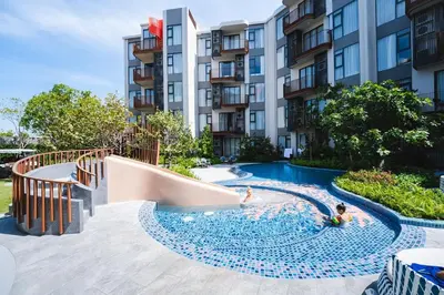 a pool with a slide in front of a building at Casa tua, luxury 2bed - Canvas by Sansiri in Laguna Phuket