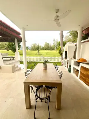 a wooden table and chairs on a patio at Coastal Villa on Fairway 3 Bedroom in Laguna Phuket