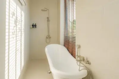 a white bathroom with a tub and a shower at Taraburi 6BR Pool Villa Phuket VVPHU91 in Thalang