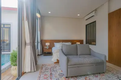 a bedroom with a couch and a bed and a window at Taraburi 6BR Pool Villa Phuket VVPHU91 in Thalang
