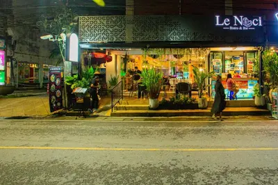 a woman walking down a street in front of a store at Aonang room rent in Ban Khlong Haeng