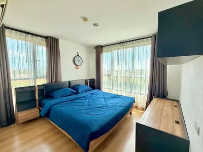 a bedroom with a blue bed and two windows at MiCasa - 2BR Centrio 7th Floor in Ban Rangeng