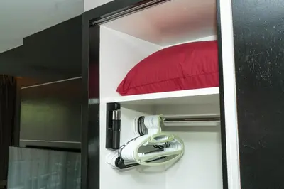 a room with a red pillow and a hair dryer at Beachfront 1 Deluxe BR Luxury Pool Patong Phuket in Patong Beach