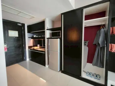 a kitchen with black cabinets and a white refrigerator at Beachfront 1 Deluxe BR Luxury Pool Patong Phuket in Patong Beach