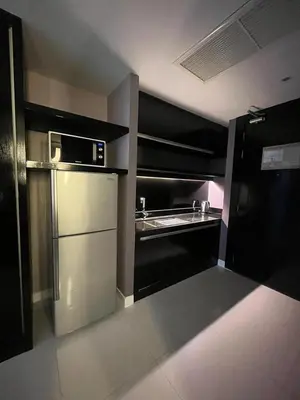 a kitchen with a refrigerator and a microwave at Beachfront 1 Deluxe BR Luxury Pool Patong Phuket in Patong Beach