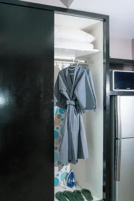 a closet with a black door and a shirt and shoes at Beachfront 1 Deluxe BR Luxury Pool Patong Phuket in Patong Beach