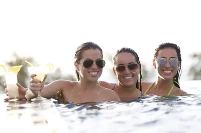 three women in the water with a drink at Beachfront 1 Deluxe BR Luxury Pool Patong Phuket in Patong Beach