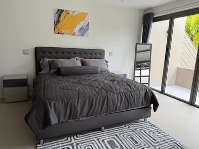 a bedroom with a bed with a gray comforter at Bella Home 2BR Pool Villa min to Bang Tao Beach in Ban Thalat Choeng Thale