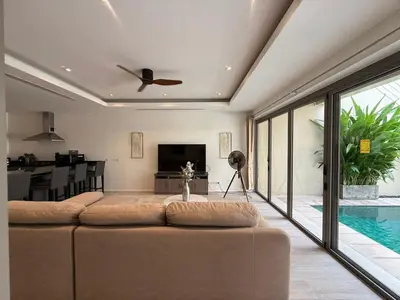 a living room with a large couch and a tv at Bella Home 2BR Pool Villa min to Bang Tao Beach in Ban Thalat Choeng Thale