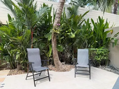 two chairs sitting in front of palm trees at Bella Home 2BR Pool Villa min to Bang Tao Beach in Ban Thalat Choeng Thale