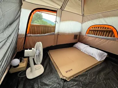 a small tent with a bed and a fan in it at The Tent Naiyang in Nai Yang Beach
