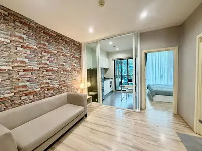 a living room with a brick wall and a couch at The base up town phuket