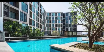 a swimming pool in front of a large building at The base up town phuket