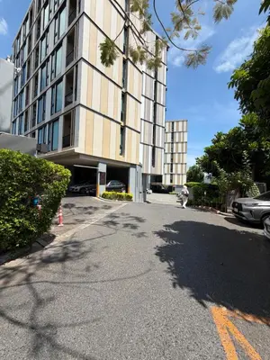 a tall building with a parking lot in front of it at The base up town phuket