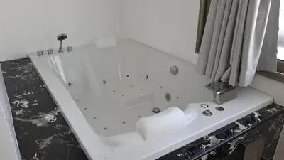 a white bath tub sitting next to a window at PATONG TOWER 5's STAR in Patong Beach