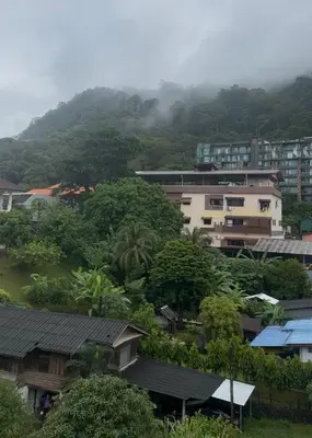 a city with buildings and trees and a mountain at Top hotel in Patong Beach