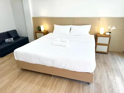 a bedroom with a large white bed and a couch at Top hotel in Patong Beach