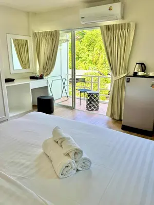 a white bed with a pile of towels on it at Top hotel in Patong Beach