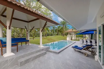 a patio with a pool and chairs and a house at Elegant 2BR Pool Villa Overlooking Loch Palm Golf - Baan Sawan Garden Villa in Kathu