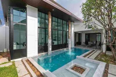 a swimming pool in front of a house at Mono Villas Pasak - Three Bedroom Pool Villa in Bangtao in Ban Pak Lak