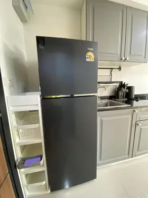 a black refrigerator in a kitchen with its door open at 777 Beach Condo in Ban Mai Salae