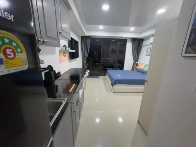 a kitchen and a bedroom with a bed in a room at 777 Beach Condo in Ban Mai Salae