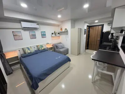 a bedroom with a bed and a desk in it at 777 Beach Condo in Ban Mai Salae
