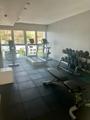 a gym with dumbbells and weights in a room at Phuket Kata Studio Apartment in Kata Beach